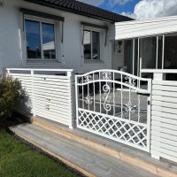 Smidesgrind Emelie, hållbar gånggrind i vitlackerat stål. Varmförzinkad yta skyddar mot väder, perfekt för entré och trädgård. Vit gånggrind i smide, modell Emelie, höjd 95cm. Robust, varmförzinkad och pulverlackerad för hållbarhet och säkerhet.
