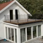Måttanpassat balkongräcke B6 i smide, varmförzinkat och pulverlackerat i svart ultramatt, monterat i Stenungsund. Svart smidesräcke B6 på balkong i Stenungsund, 110 cm högt och måttanpassat med infästning ovanpå trägolvet.